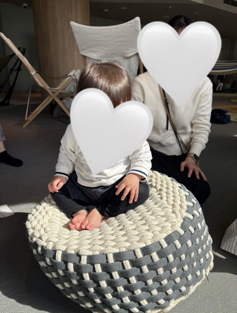 SKY PLAZA IBASHOの床座クッションで親子が並んで座り、リラックスして過ごしている様子。