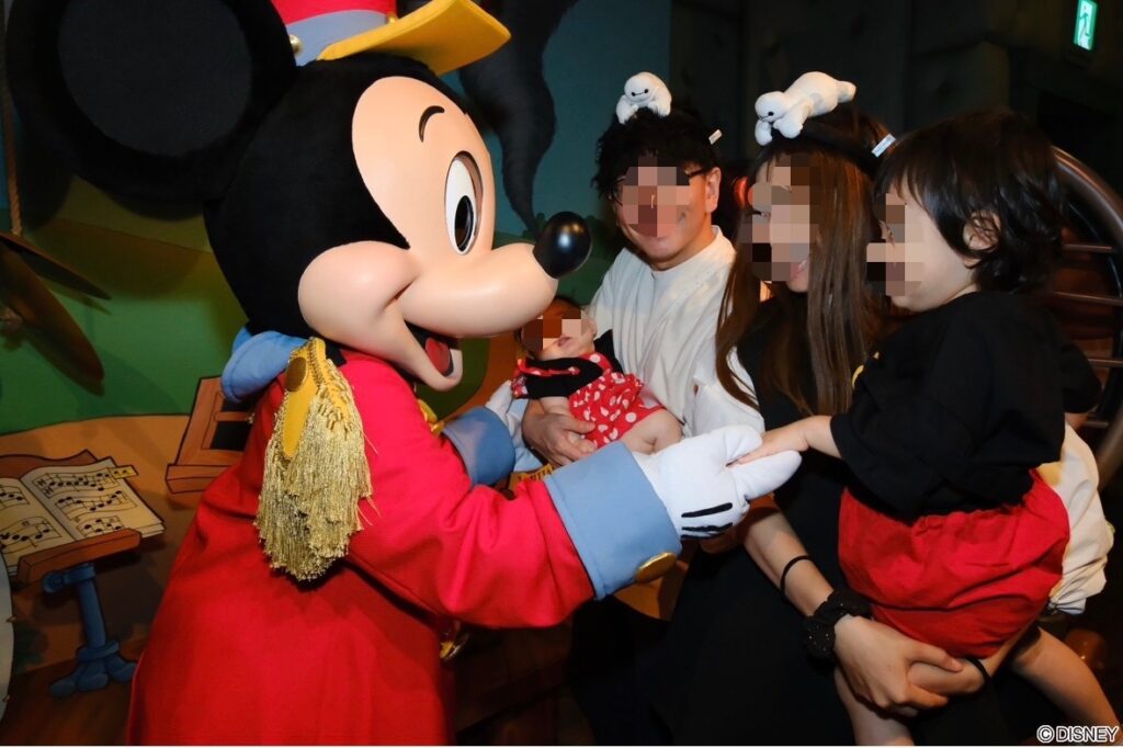 ミッキーと子どもが触れ合うグリーティングの様子。初めての対面に喜ぶ子どもの表情が印象的